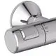 Brausethermostat aus Chrom von Ideal Standard, mit Bedienelement und Temperaturskala, montiert an der Wand, Teil einer Duschanlage.